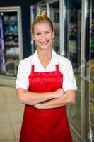 Smiling shop assistant with arms crossed
