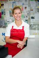 Smiling shop assistant with arms crossed