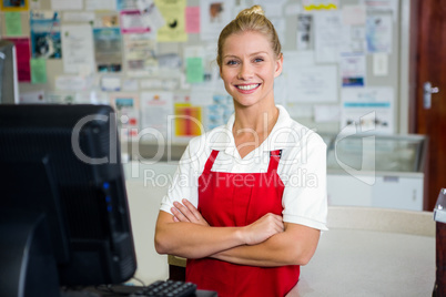 Smiling shop assistant with arms crossed