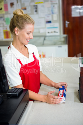 Smiling shop assistant looking at product