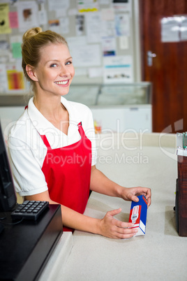 Smiling shop assistant looking at product