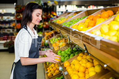 Portrait of a smiling worker taking a fruits