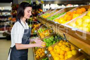 Portrait of a smiling worker taking a fruits