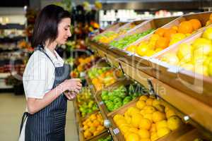 Portrait of a smiling worker taking a fruits