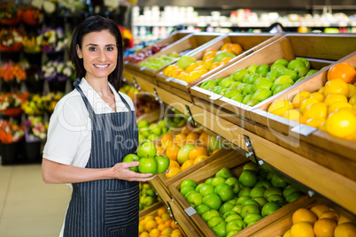 Portrait of a smiling worker taking a fruits