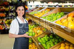 Portrait of a smiling worker taking a fruits