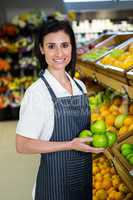 Portrait of a smiling worker taking a fruits