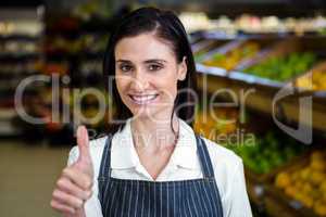 Smiling young worker with thumbs up