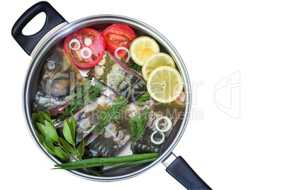 Fish and components for her preparation in a large skillet.