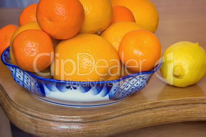 Oranges and tangerines in a beautiful ceramic vase.