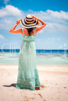 Girl walking along a tropical beach in the Maldives.