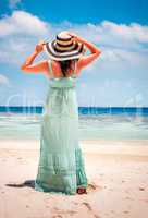 Girl walking along a tropical beach in the Maldives.