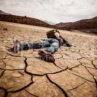 person lays on the dried ground