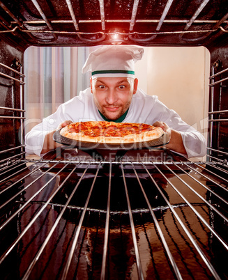 Chef cooking pizza in the oven.