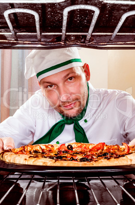 Chef cooking pizza in the oven.