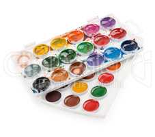 New and used watercolor paints in palette isolated on white background