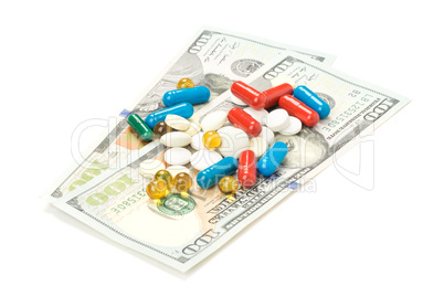 One hundred dollars banknotes and pill isolated on white background