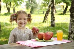 little girl with apple and juice in park