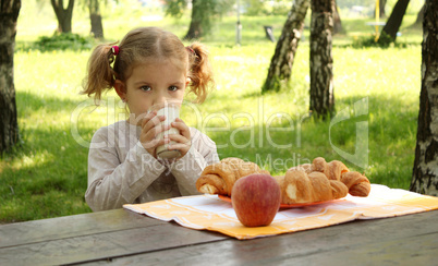 young girl drink milk in park