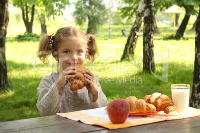 young girl eat croissant