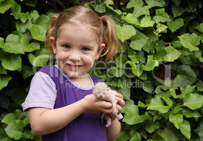 little girl holding three day old cat