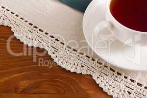 Background with openwork napkin and cup of tea