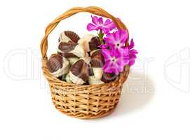 Chocolates in a wattled basket on a white background.