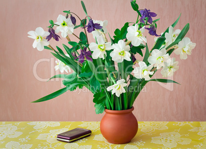 Blossoming narcissuses in a vase on a table.