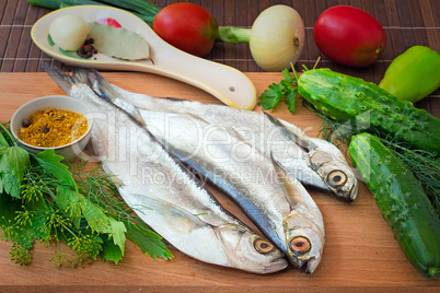 Fish and components for her preparation: vegetables, spices, par