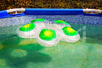 Fragment of the pool and rubber rubber ring on a water surface.