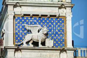 Winged lion on facede of the bell tower at San Marco square in V