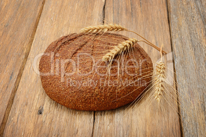 bread and ears of wheat on the wooden table