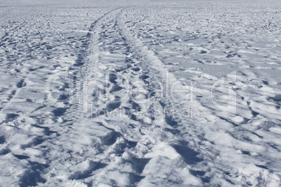 Wheel track and human footprints on the snow