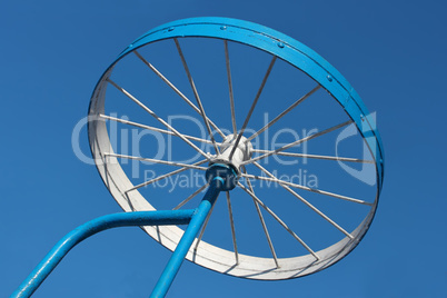 Metal detail as a bicycle wheel against the sky