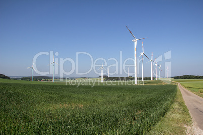 Windmill generator in wide yard / Yard of windmill power generatorunder blue sky, shown as energy industry concept.