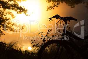 Bike on the lake in front of the setting sun