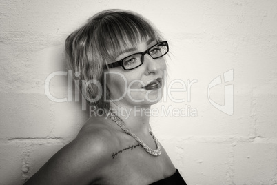 Frau mit Brille steht vor einer weißen Wand
