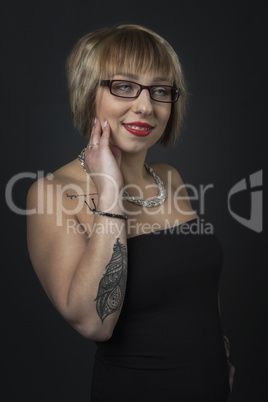 Brillenträgerin mit Tattoo im Kleid