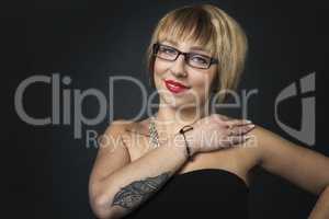 Frau mit Brille hat ein Tattoo am Unterarm