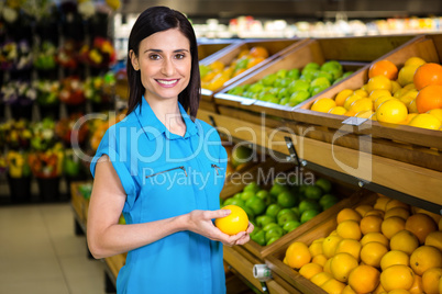 Portrait of a smiling woman picking orange