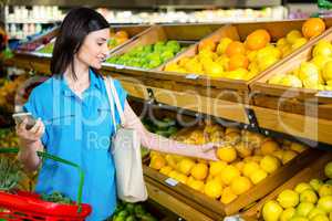 Portrait of a smiling woman picking orange