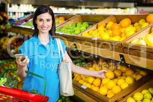 Portrait of a smiling woman picking orange