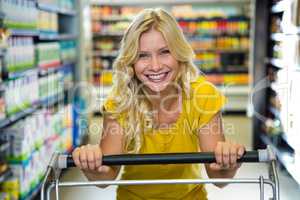 Portrait of a smiling pretty blonde woman in aisle