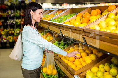 Portrait of a smiling woman buying oranges