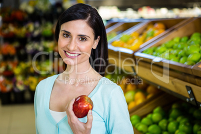Portrait of a smiling woman picking apple