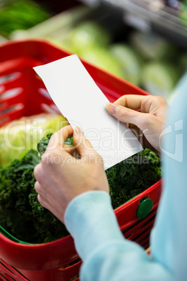 Mid section of a woman with grocery list