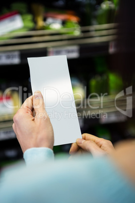 Mid section of a woman with grocery list