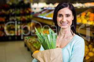 Smiling woman holding grocery bag