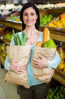 Smiling woman holding grocery bag