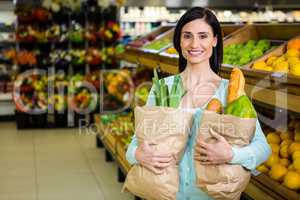 Smiling woman holding grocery bag